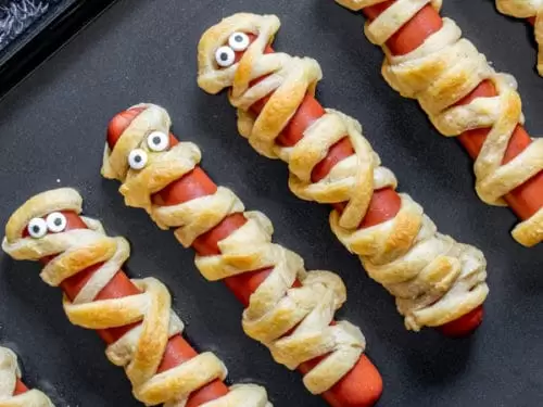 Mouthwatering finished dish piled high with golden brown, flaky crescent dough and bright yellow mustard eyes—your new favorite Halloween party finger food ready in a flash.