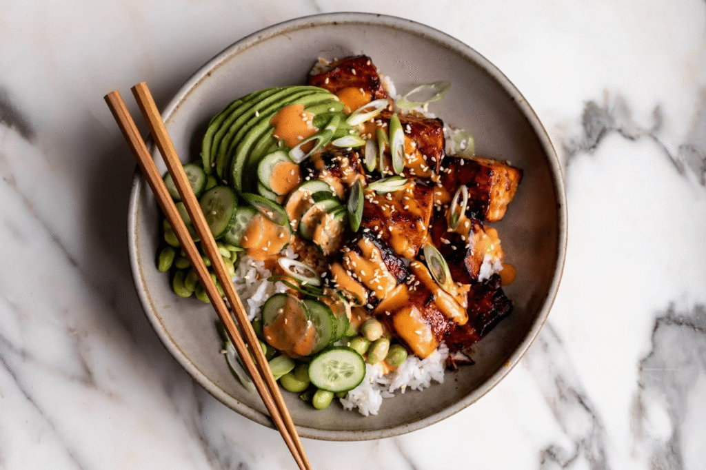 A vibrant teriyaki salmon bowl piled high with flaky, glazed fish, fluffy rice, and a confetti of fresh veggies—your new favorite fakeout takeout meal